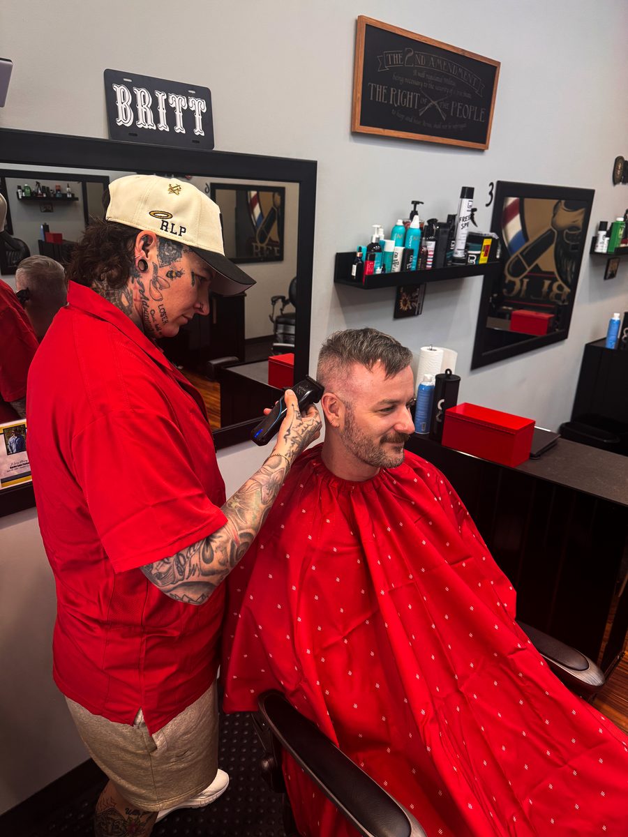 A Razor Republic barber cutting a client's hair in the shop