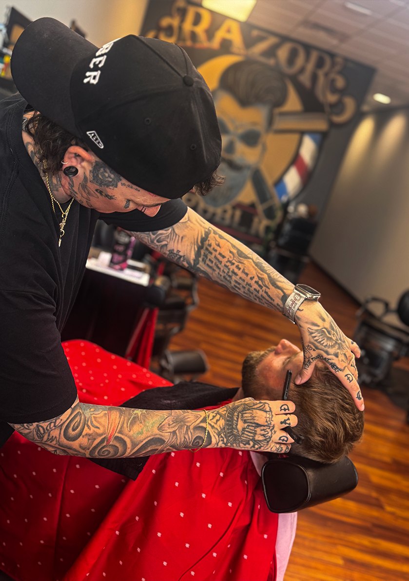 A Razor Republic barber doing detailed razor work on a client